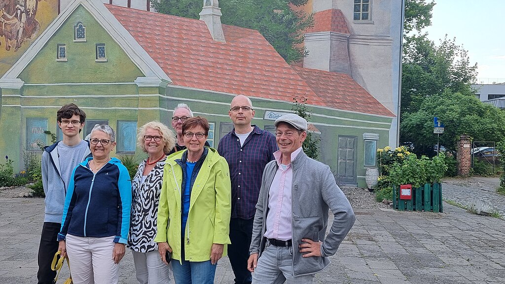 Nach Anweisung an die freundliche Fotografin postierte sich das Team Wikipedia Hannover gemeinsam mit Marcin aus Poznań (Posen) am 17. Juni 2023 zum Gruppenbild vor der großen Wandmalerei auf der Insel Śródka ...