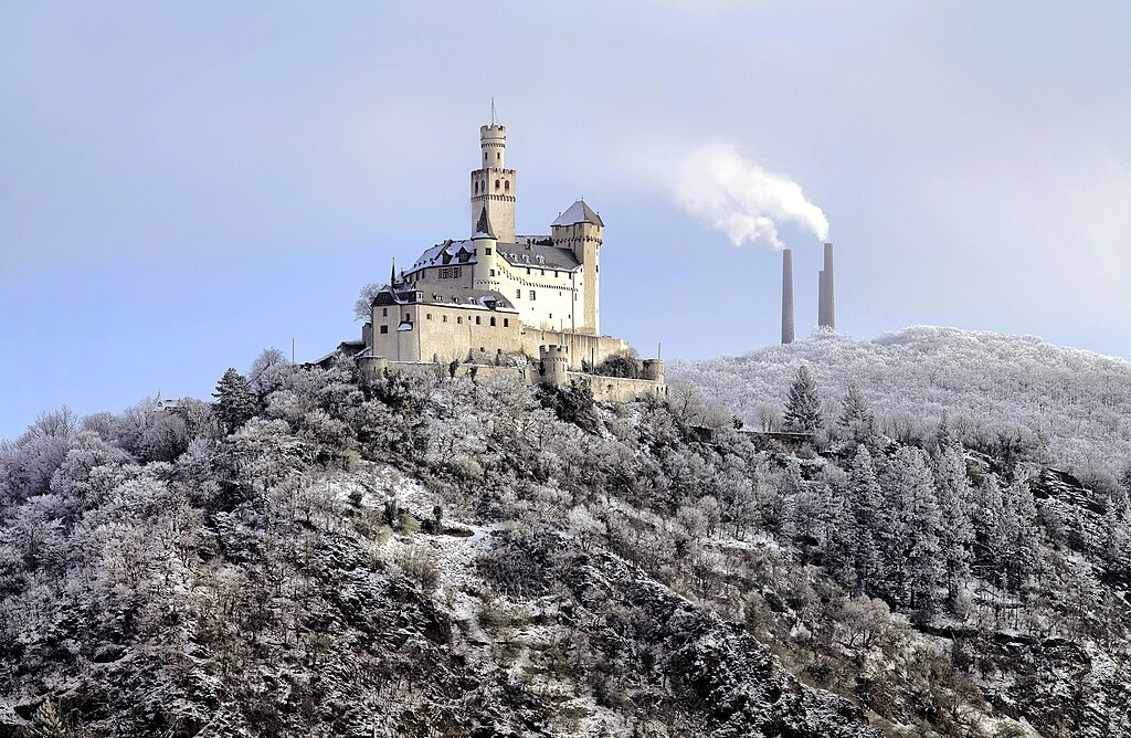 Burg Marksburg im Winter, rechts davon die markanten Schornsteine der Braubacher Blei- und Silberhütte, eines der ältesten Industriedenkmäler im Mittelrheingebiet.