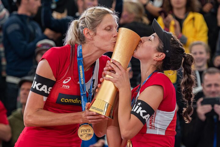 BeachVolleyball-Spielerinnen mit Pokal