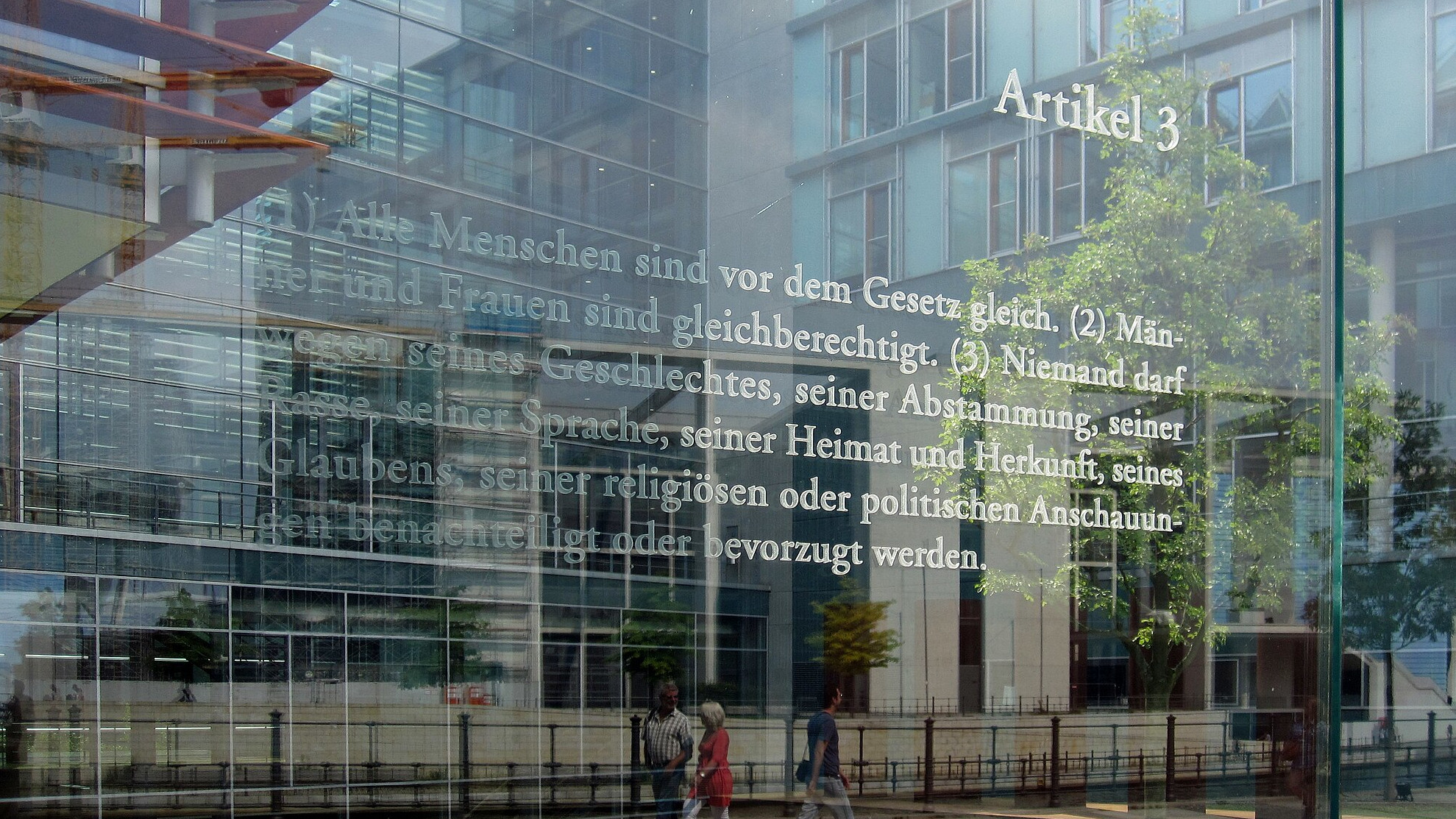 Der israelische Künstler Dani Karavan hat in drei Meter hohe Glasscheiben, die einen Außenhof des Jakob-Kaiser-Hauses im Uferbereich zur Spree begrenzen, die 19 Grundrechtsartikel des Grundgesetzes mit Laser eingraviert. Hier ist der dritte Artikel zu sehen.