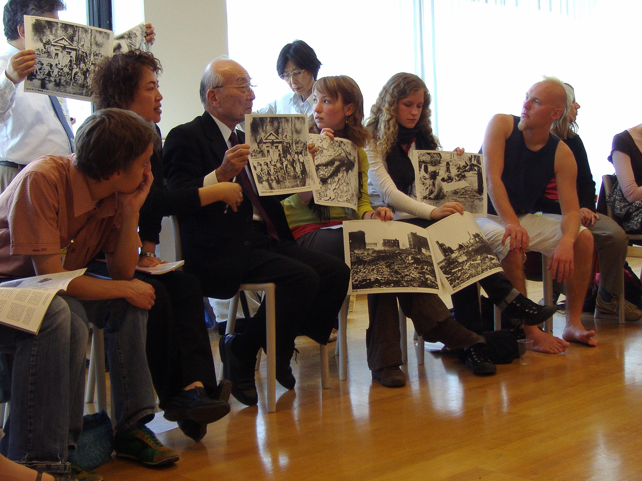 Terumi Tanaka, einer der Vorsitzenden von Nihon Hidankyō und Überlebender des Atombombenabwurfs auf Nagasaki, erzählt Jugendlichen von seinen Erlebnissen.