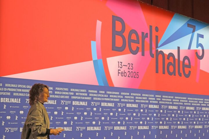 Tricia Tuttle auf der Pressekonferenz der 75. Berlinale. Hinter ihr ist ein großes Plaket mit dem Logo der Berlinale zu sehen.