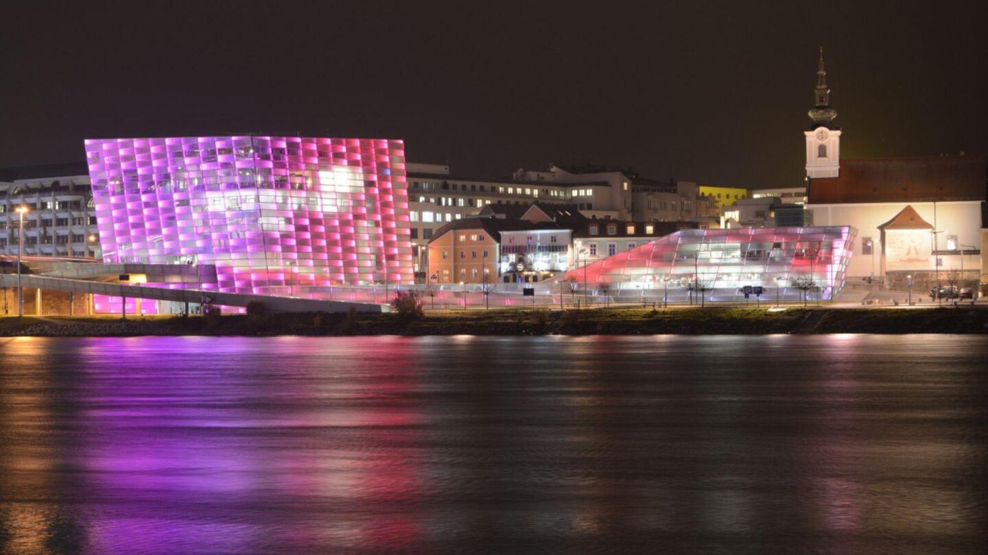 Blick aufs Ars electronica center lila erleuchtet und die Stadt Linz