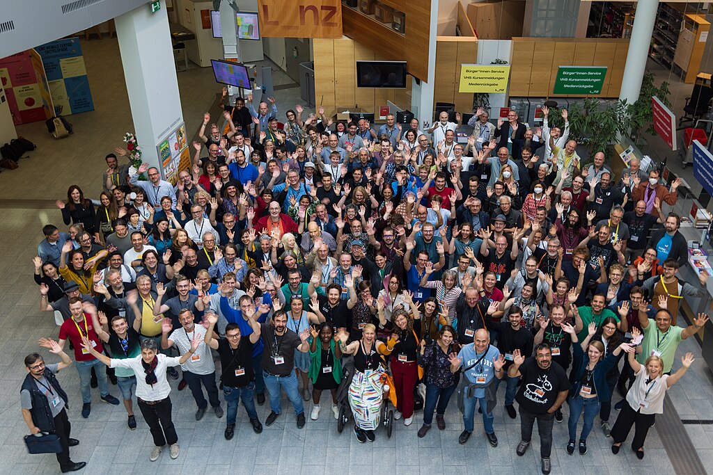 So sehen sie aus, die Autorinnen und Autoren der Wikipedia! Vielleicht bist du schon bald dabei? In der Regel einmal pro Jahr treffen sie sich auf einer großen Konferenz namens WikiCon. Das Bild hier entstand 2023 im österreichischen Linz.