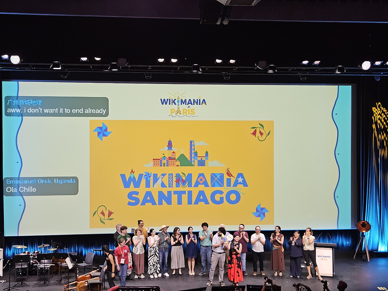 Menschen auf einer Bühne, im Hintergrund der Schriftzug: "Wikimania Santiago".