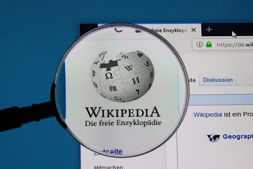 Lupe vor Wikimedia-Logo auf Bildschirm