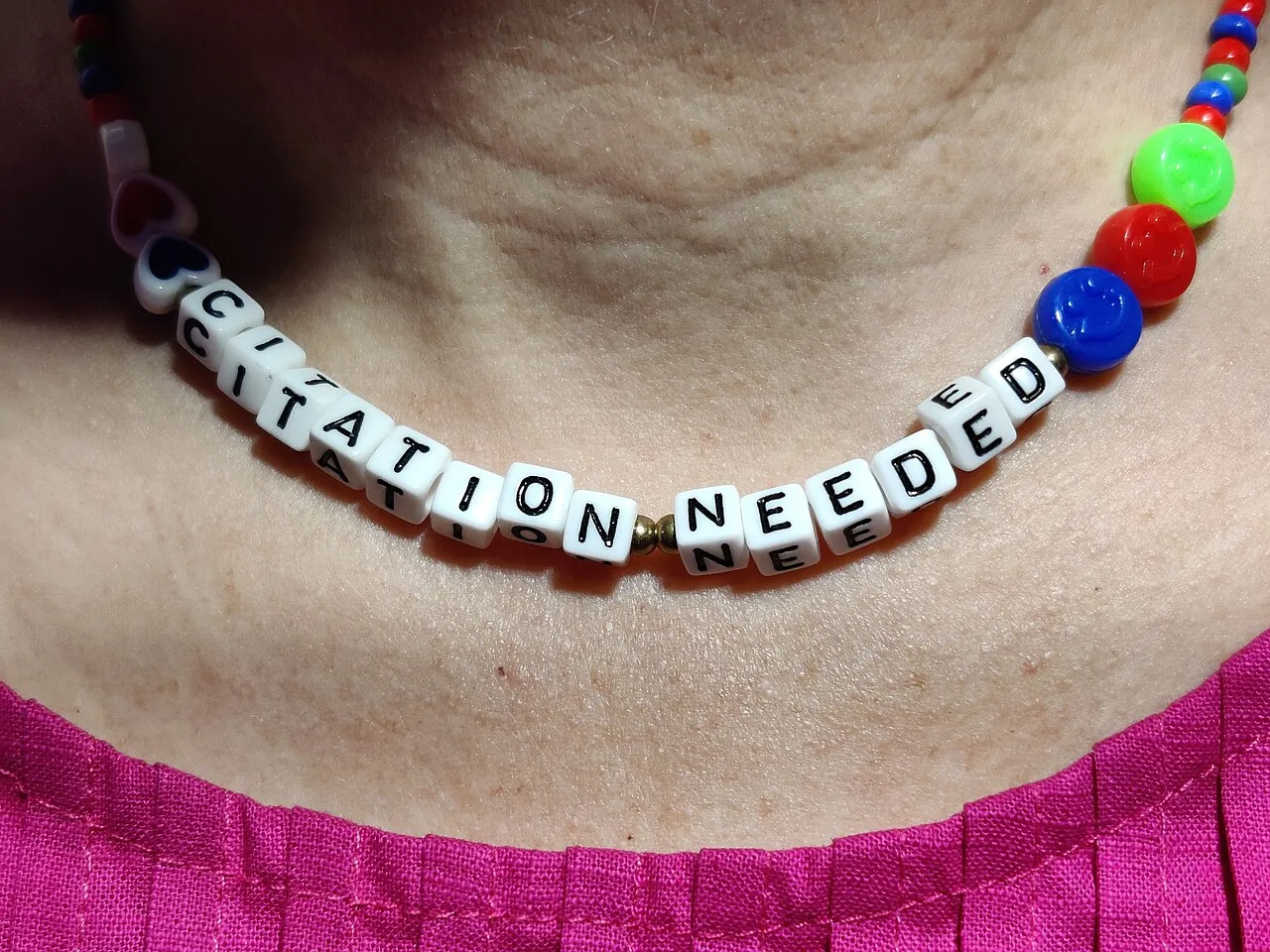 Eine Halskette mit den Wörtern: "Citation Needed".