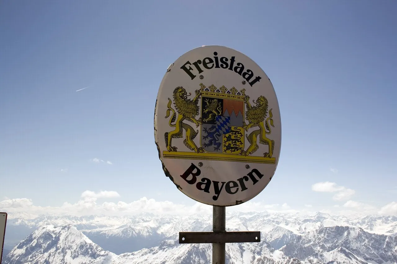 Schild auf einerm Bergipfel mit der Aufschrift: "Freistaat Bayern"