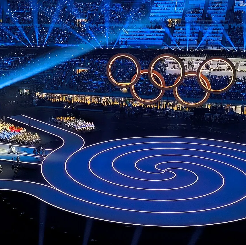 Die Olympischen Ringe schweben über einer runden Bühne.
