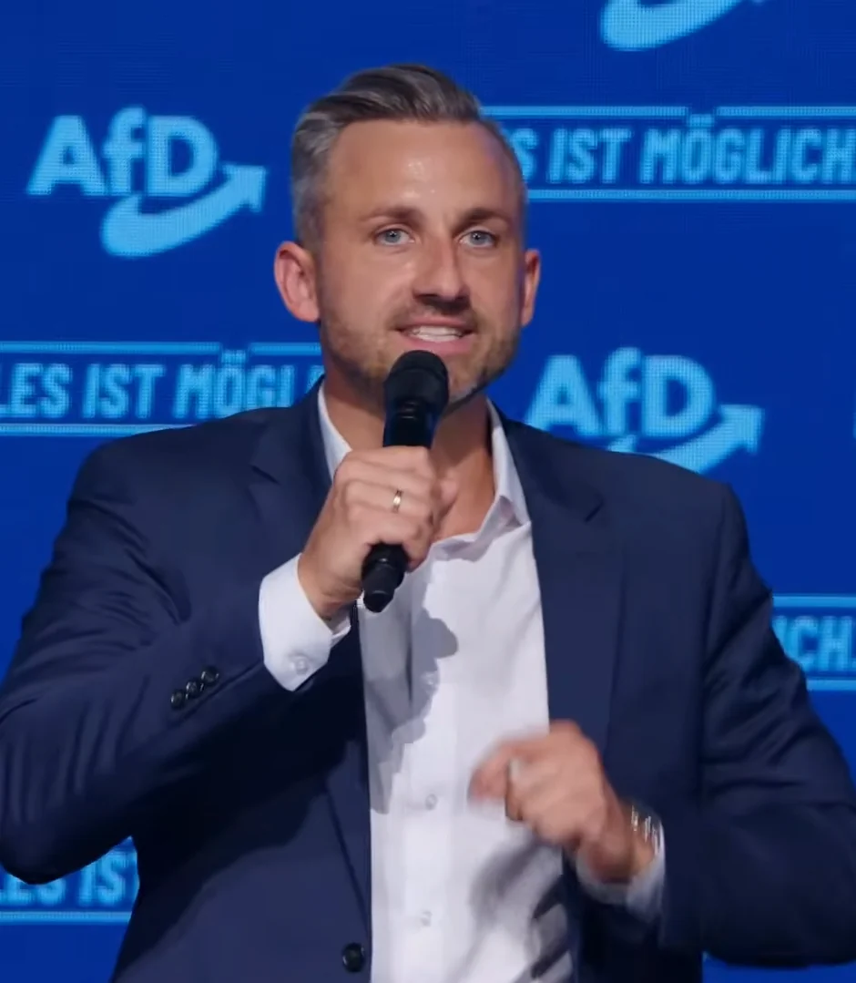 Ulrich Siegmund mit einem Mikrofon auf einer Bühne.