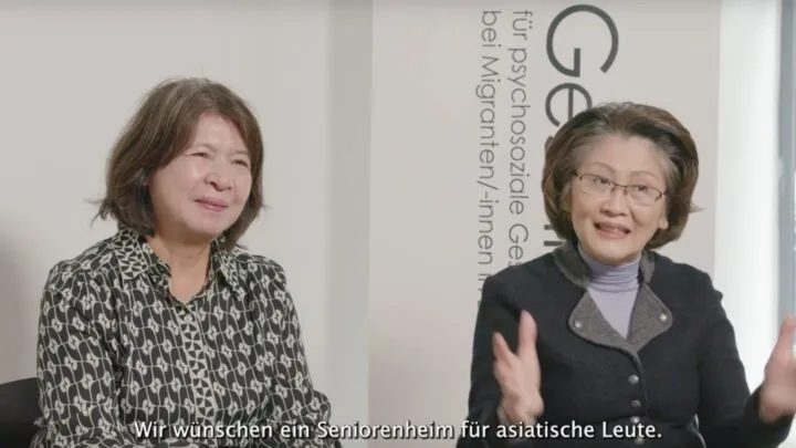 Zwei Frauen sitzen nebeneinander. Untertitel: Wir wünschen ein Seniorenheim für asiatische Leute.